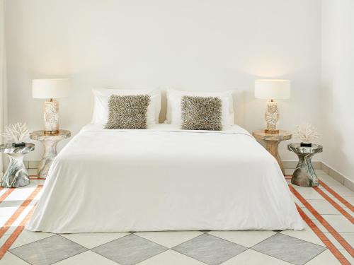 a white bed in a white bedroom with two lamps at Mandola Rosa at Riviera Olympia, A Grecotel Resort to Live in Loutra Killinis