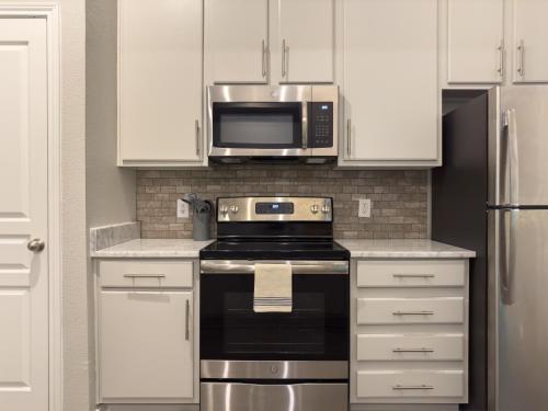 a kitchen with a stove and a microwave at Monthier Downtown RI1S1U1 in Austin
