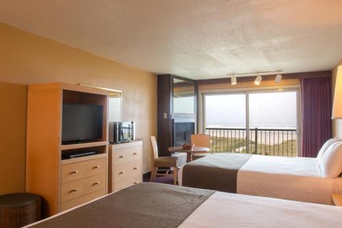 Habitación de hotel con 2 camas y TV en Hi Tide Oceanfront Inn en Seaside