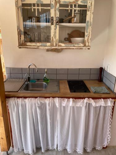 a kitchen counter with a sink and a mirror at Blue Abyss Apartment in Susak