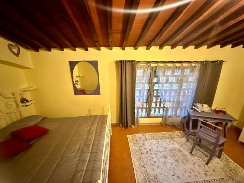 蓬塔謝韋的住宿－Agriturismo Tassinaia，一间卧室配有一张床、一张桌子和一个窗户。