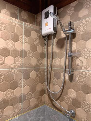 a shower in a bathroom with a shower head at Ruean Yai Jieam เรือนยายเจียม in Pak Kret