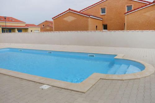 une piscine avec de l'eau bleue dans une cour arrière dans l'établissement jolie villa lumineuse - proche plage, à Torreilles