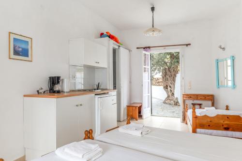 a white kitchen with two beds in a room at Sifnos studio 5 in Sifnos