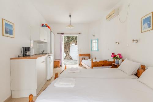 Habitación blanca con 2 camas y cocina en Sifnos studio 5 en Sifnos