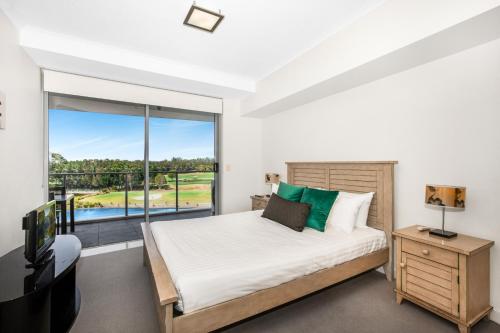 a bedroom with a bed and a large window at Lakeside Family Oasis with Pool, Gym and Balcony in Gold Coast