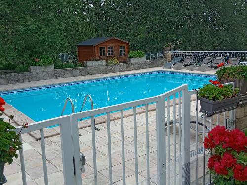 une piscine avec des chaises à côté d'une clôture dans l'établissement Les Papillons, à Labeaume