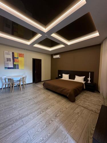 a bedroom with a bed and a table and chairs at Hotel Atmosphere in Poltava