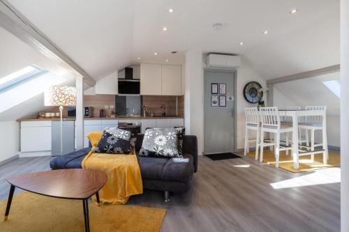 un salon avec un canapé et une table et une cuisine dans l'établissement Hearten - Mulhouse bnb, à Mulhouse