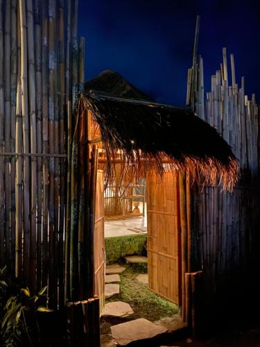 a small wooden shed with a thatch roof at Nivriti Bali in Sidemen