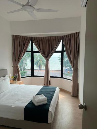 a bedroom with a bed and a large window at Mutiara Melaka Beach Resort - Islamic Compliance Only in Tangga Batu