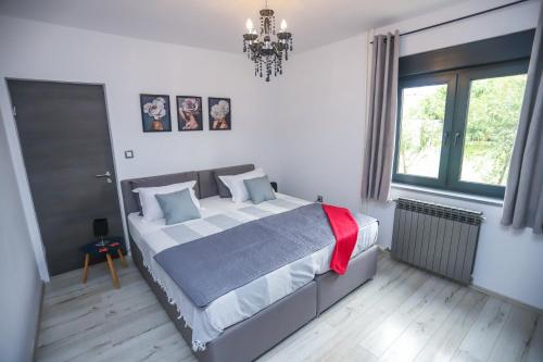 - une chambre avec un grand lit et un lustre dans l'établissement Apartment Tina II, à Poreč