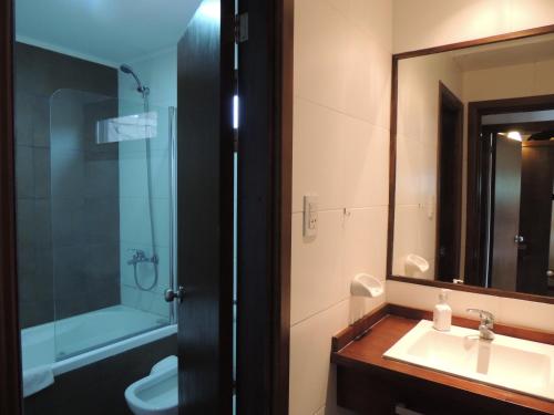 y baño con lavabo, ducha y espejo. en Cabañas Klippen en Mar del Plata