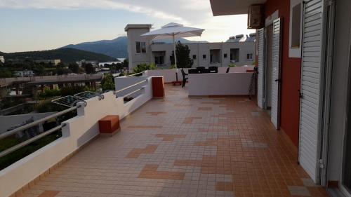 a balcony of a house with a table and an umbrella at Villa Papa in Ksamil