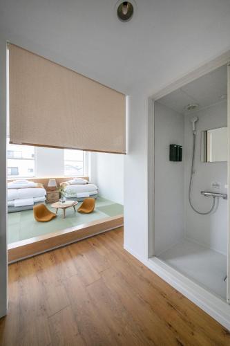a bathroom with a shower and a room with two beds at ぷふか浅草 in Tokyo