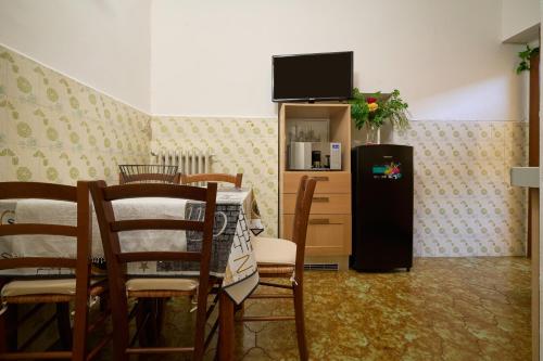 a dining room with a table and a refrigerator at Carmelita in Massa Marittima