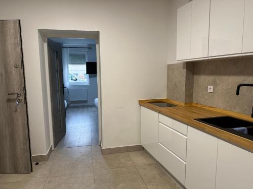 a kitchen with white cabinets and a door to a hallway at Guben Wohnungen in Guben