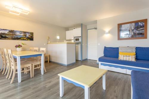 un salon avec un canapé bleu et une table dans l'établissement Appartement vue mer sur plage, à Douarnenez