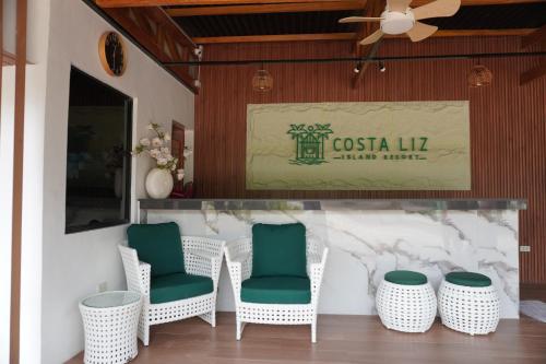 a group of chairs and a bar with a sign at Costa Liz Island Resort in Pooc