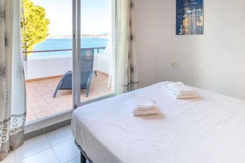 a bedroom with a bed and a view of the ocean at Grifeu 151 - Casa adosada con piscina comunitaria in Llança