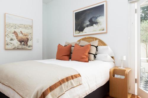 a bedroom with a bed with orange pillows at Chic Studio With Patio 20 min From CBD in Sydney