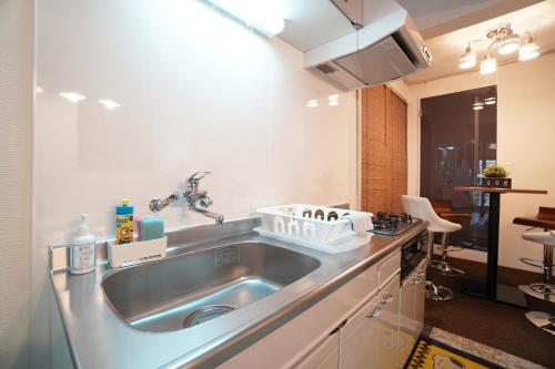 uma cozinha com um lavatório de aço inoxidável num quarto em Sakurajima Parkside House A em Osaka