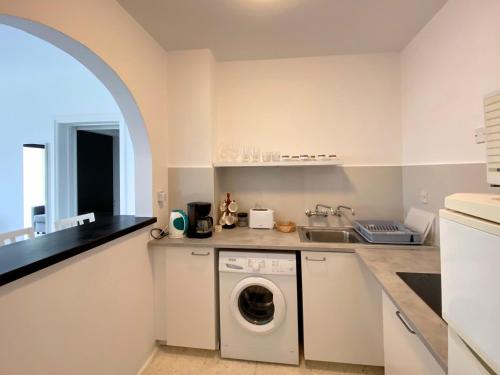 a white kitchen with a washer and dryer at 1st Class Location with Sea&Pool View in Paphos
