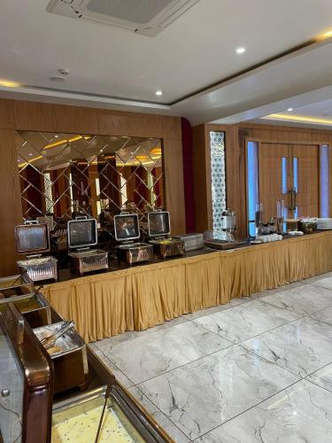 a lobby with a long counter with several televisions at Hotel Three Seasons in Vrindāvan