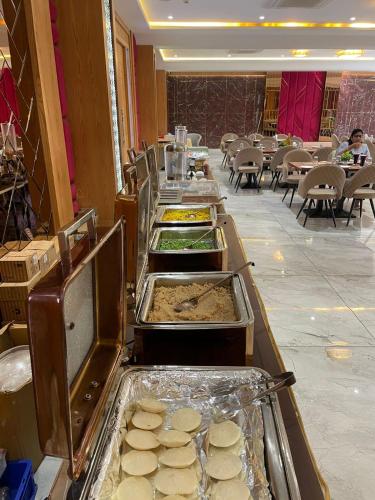 a buffet line with trays of food in a restaurant at Hotel Three Seasons in Vrindāvan