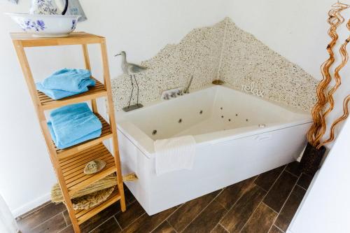 a bath tub in a bathroom with a wall at Anker's Hörn - Hotel & Restaurant auf der Hallig Langeness in Langeneß