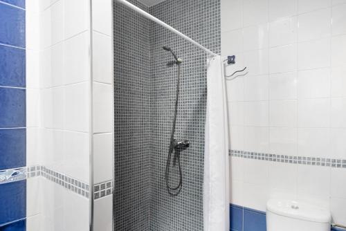 a shower with a glass door in a bathroom at Casa Buganvilla in Conil de la Frontera