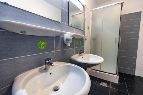 韋萊涅的住宿－韋萊涅旅舍，一间带水槽、浴缸和镜子的浴室