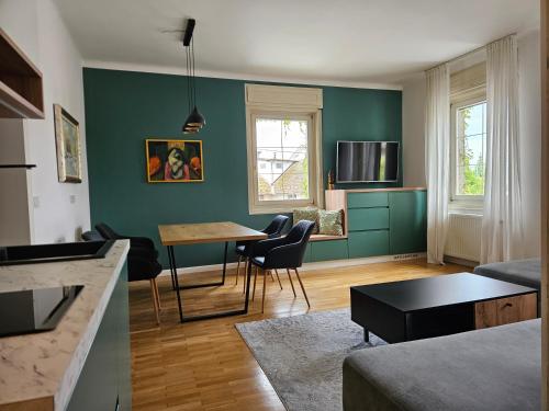 uma sala de estar com paredes verdes e uma mesa e cadeiras em Hotel Sporn em Radomlje