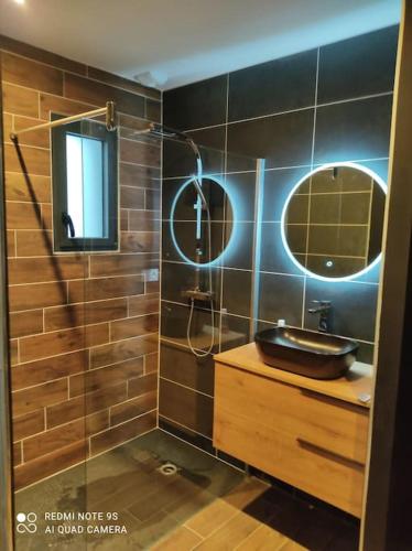 une salle de bain avec un lavabo et un miroir dans l'établissement Le Refuge des Artistes, à Vezins