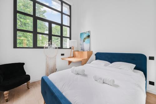 Un dormitorio con una cama azul y una silla. en L'Arty - Maison avec jardin - 6p, en Villemomble