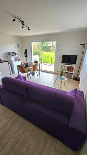 - un grand canapé violet dans le salon dans l'établissement Appartement au calme, à Bons
