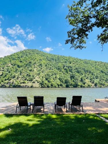 a group of chairs sitting on a dock next to a lake at CabAna Ana - Golful Bahna in Orşova