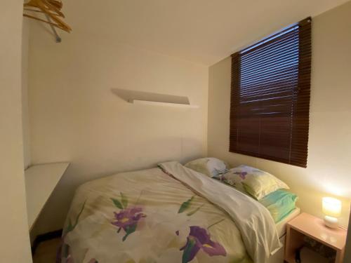 une petite chambre avec un lit et une fenêtre dans l'établissement Un pied-à-terre à Nogent-sur-marne, à Nogent-sur-Marne