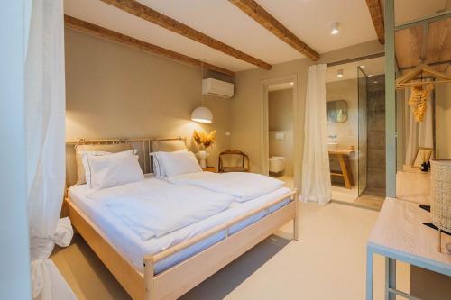 1 dormitorio con 1 cama grande y baño en Pikarin rooms, en Vrsar