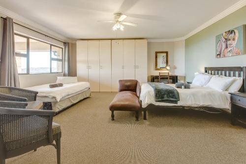 a large bedroom with two beds and a chair at Garden Route Ilita Lodge in Groot Brak Rivier