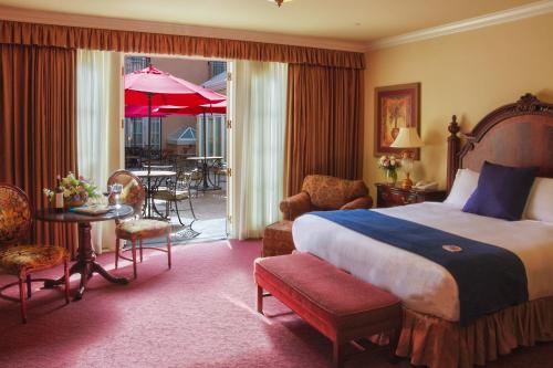 pokój hotelowy z łóżkiem, stołem i krzesłami w obiekcie Carlton Hotel w mieście Atascadero