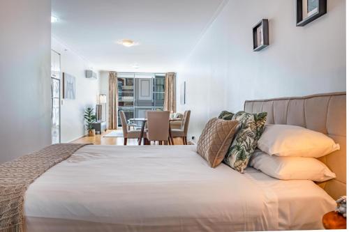 a bedroom with a bed and a dining room at Stylish Studio With Pool & Gym in Heart of Sydney in Sydney