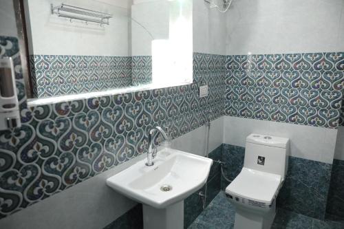 a bathroom with a sink and a toilet and a mirror at Hostel Funky Bunky in Udaipur