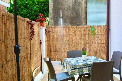 a table and chairs in front of a fence at Sea Garden Apartments in Ascea