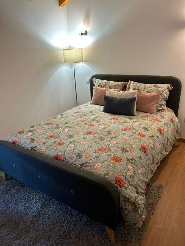 a bedroom with a bed with a blue headboard and pillows at Chalet do Soajo in Arcos de Valdevez