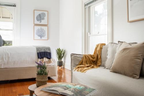 ein Wohnzimmer mit einem Sofa und einem Tisch in der Unterkunft Boutique Studio with Balcony in Perfect Location in Sydney