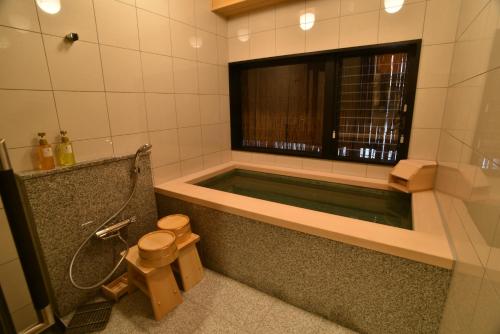 baño con bañera, aseo y ventana en Hotel Glad One Kyoto Shichijo by M's, en Kioto
