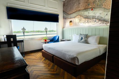 a hotel room with a bed and a large window at Polo Floatel Kolkata in Kolkata