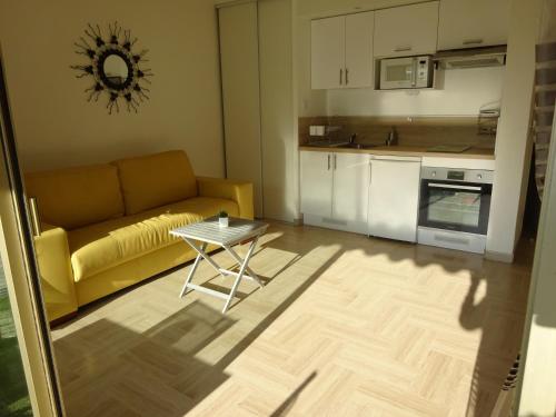 un salon avec un canapé jaune et une table dans l'établissement Studio terrasse-Croisette, Palais Festivals 10 min, à Cannes