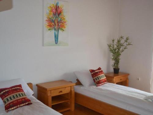 a room with two beds and a painting on the wall at Heritage Home Ustikolina in Foča